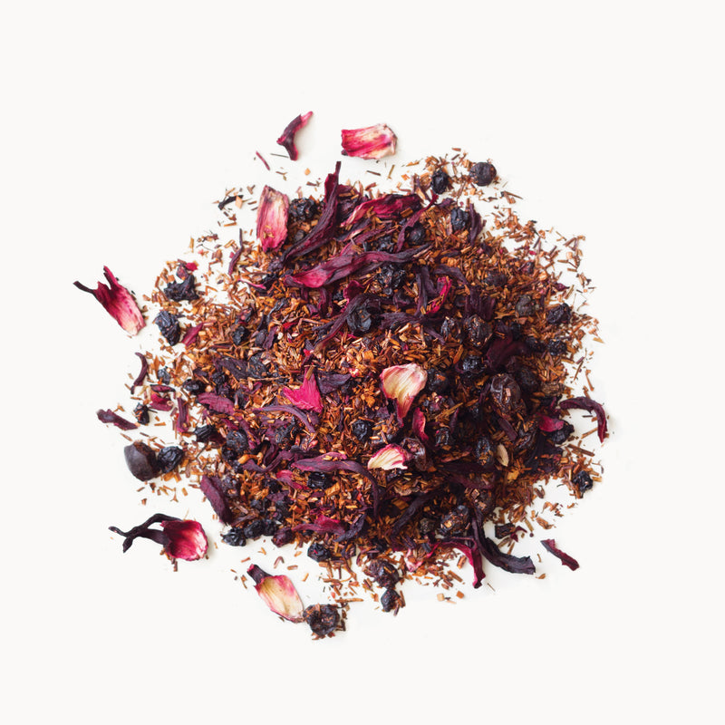 A pile of Blueberry Rooibos flowers and berries on a white background from Rishi Tea & Botanicals.