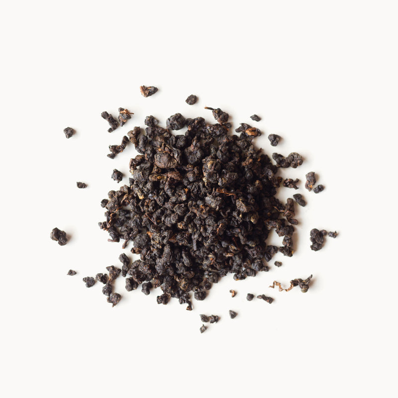A pile of Ruby Oolong tea by Rishi Tea & Botanicals on a white background.