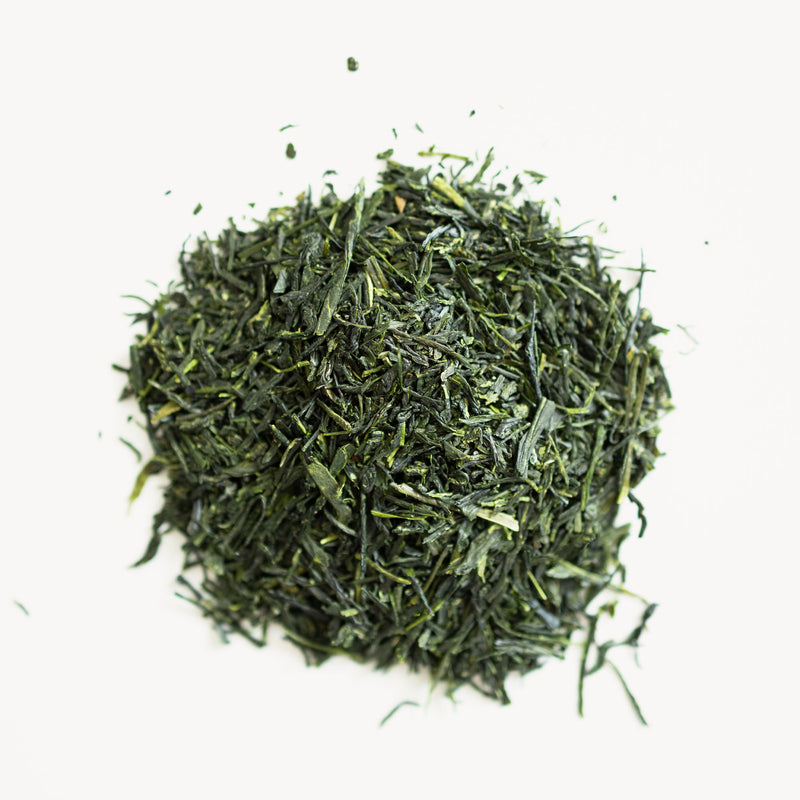 A pile of Uji Homare Gyokuro tea on a white surface in Kyoto by Rishi Tea & Botanicals.